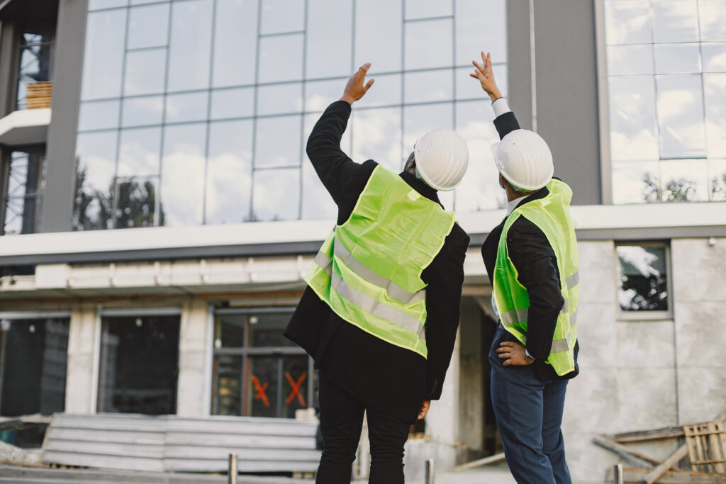 Two ingeneers discusing building project at skyscraper